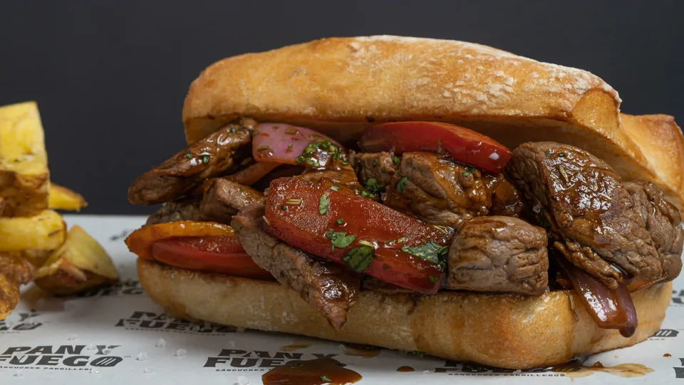 "Lomo" Saltado, bife de vacío salteado con cebolla y tomate en pan ciabatta